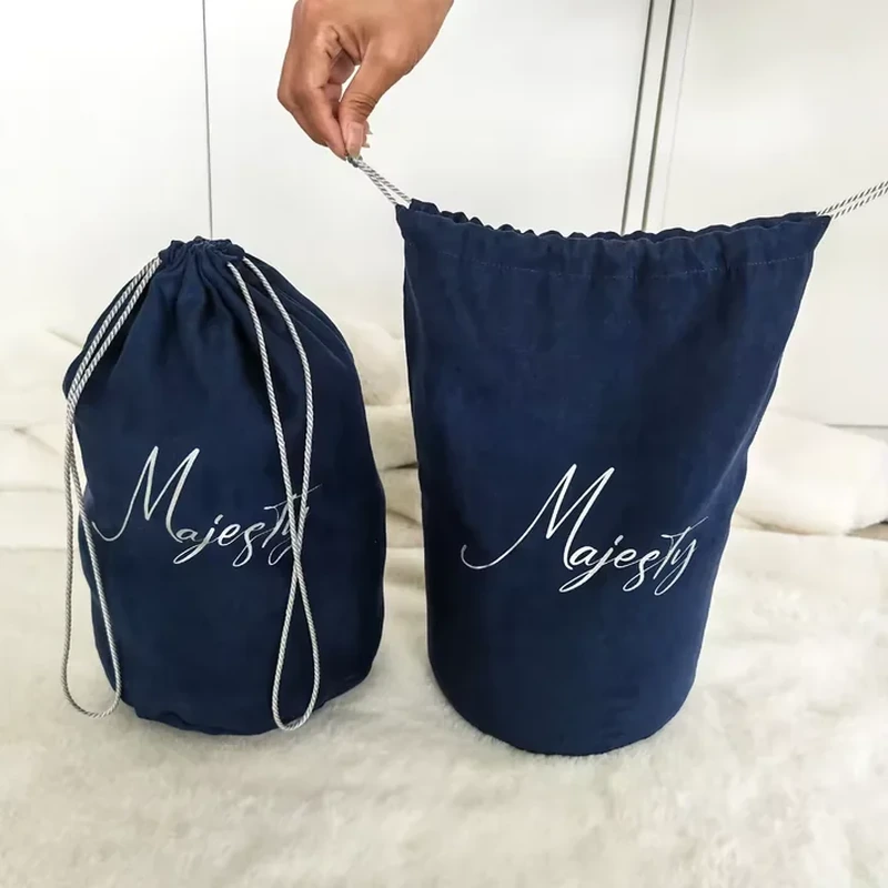 A tall barrel silhouette pairs a round base with a wide drawstring opening