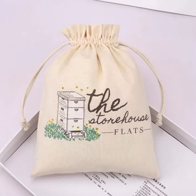 Cream drawstring pouch with a beehive illustration and printed lettering.
