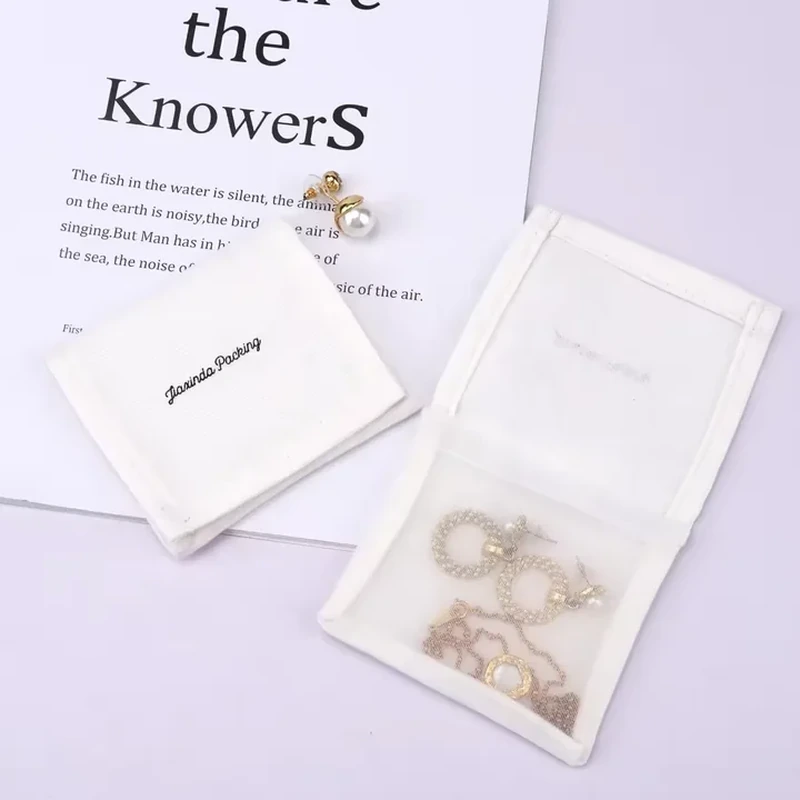 A pale folding wrap opens like a book to reveal a clear inner pocket for jewelry