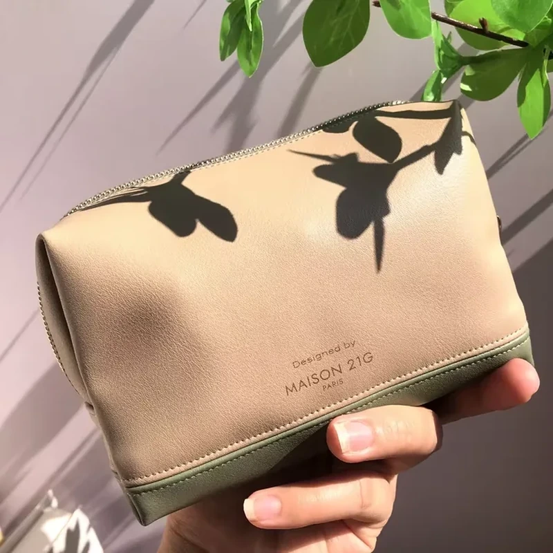 Cream leather-look cosmetic case with botanical artwork and contrasting green lower band
