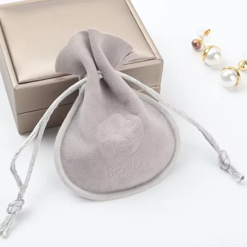 A teardrop outline and visible bound edge surround a small cord-gathered opening