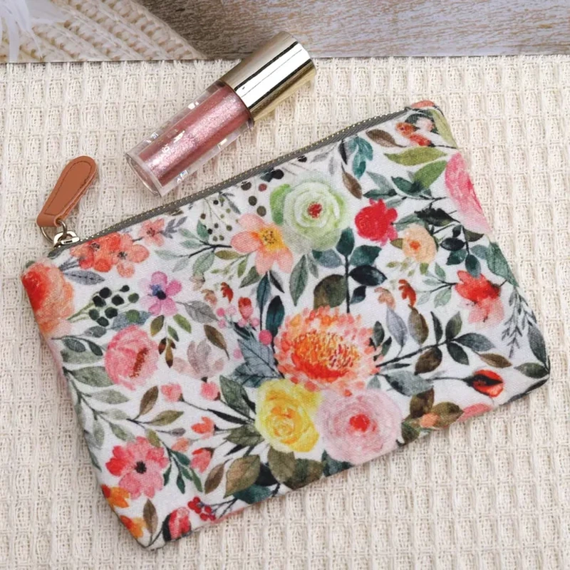 A flat zip pouch features dense colorful flowers and a contrasting zipper pull detail