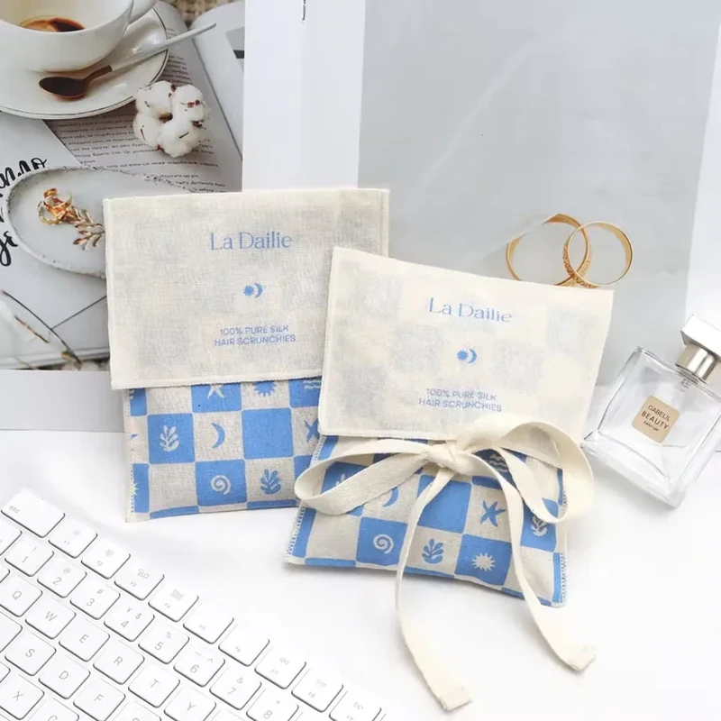 A pale foldover pouch features a blue checkerboard lower panel and a coordinating ribbon bow