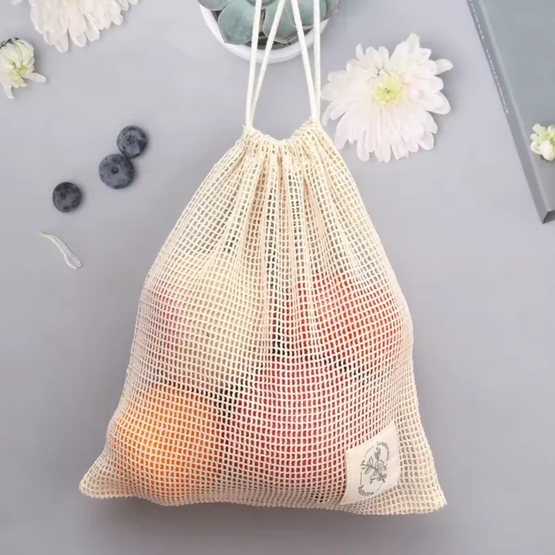 Natural coarse-mesh drawstring bag with a small corner label and visible fruit
