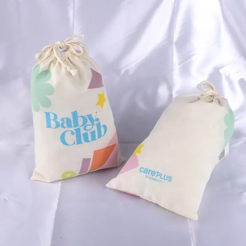A pale drawstring pouch combines large lettering with colorful blocks along its lower edge
