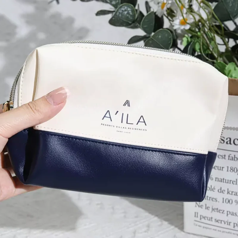 White and navy leather-look cosmetic bag with rounded top zipper and contrasting base