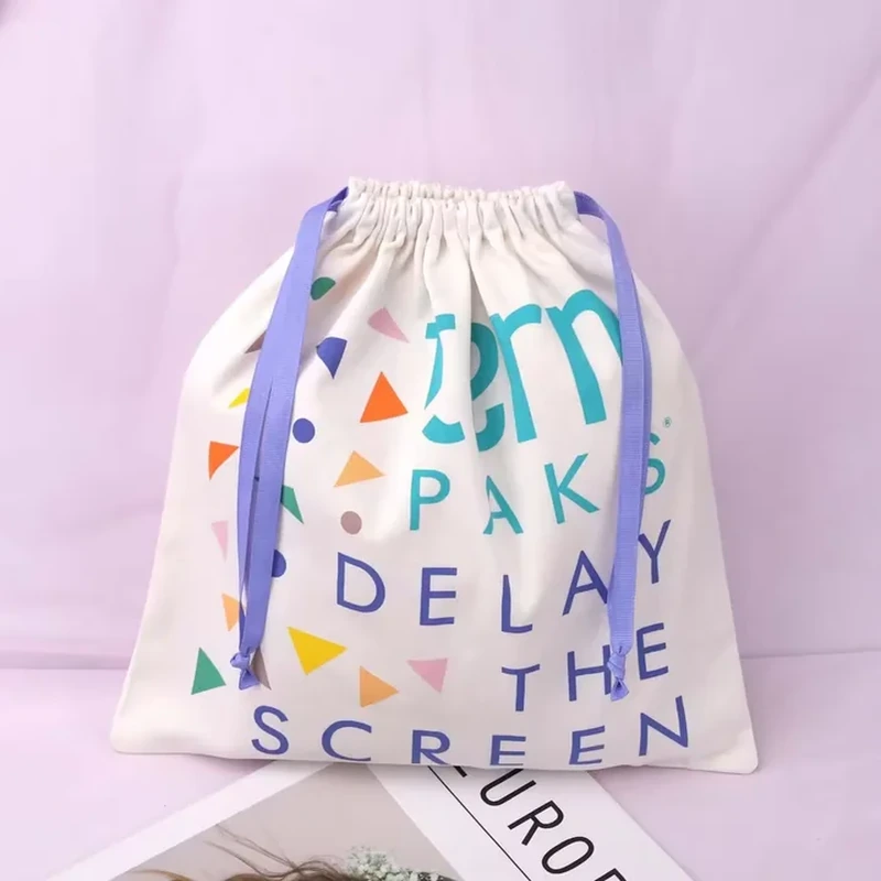 A pale drawstring sack displays oversized colorful letters and geometric accents across the front