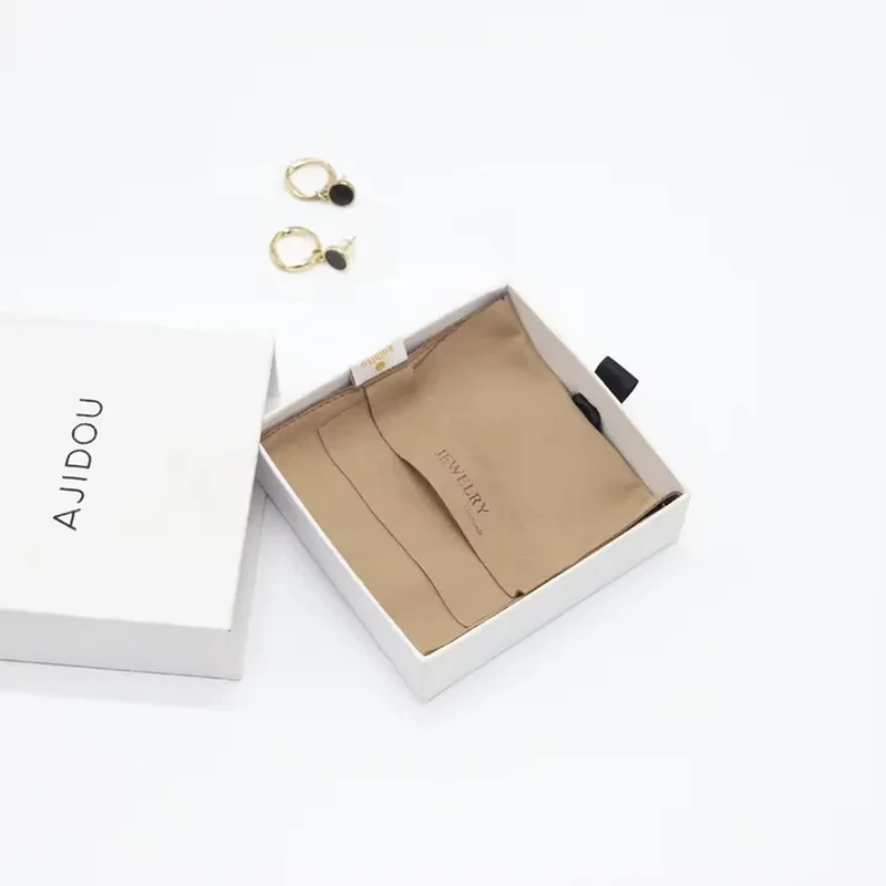 Taupe jewelry wallet with layered foldover pockets, presented in a white box.