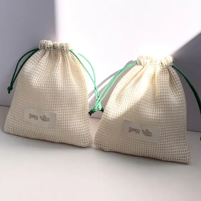 Cream grid-mesh pouches with green drawstrings and small front printing