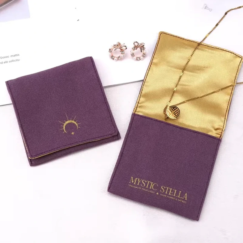 A small purple envelope opens to reveal a contrasting gold tone interior and necklace presentation