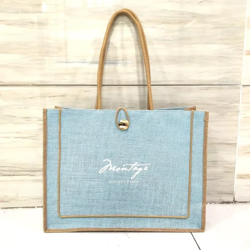 Woven tote with blue front panel, rope handles and metal clasp