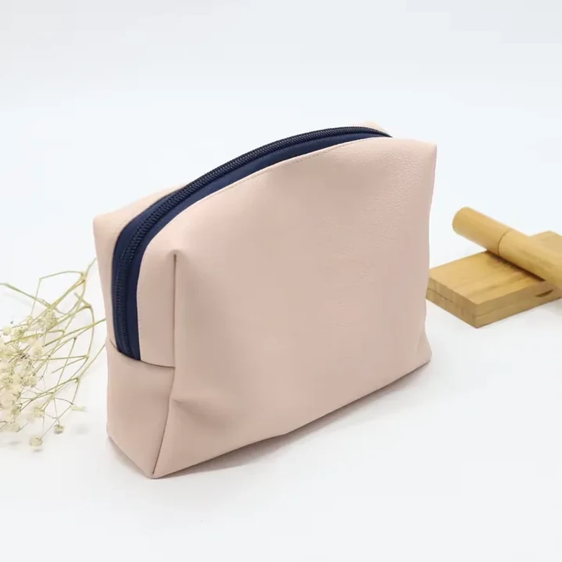 Cream leather-look wash bag with dark top zipper and boxed corners