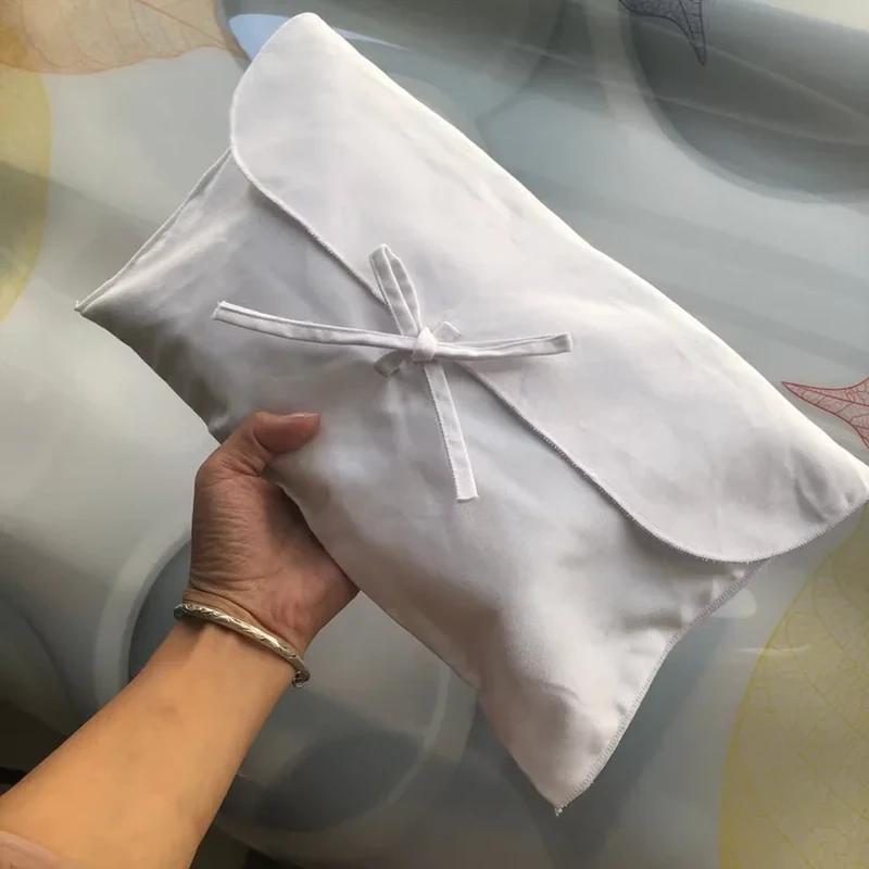 An envelope style wrap folds around the contents and closes with narrow crossing ties