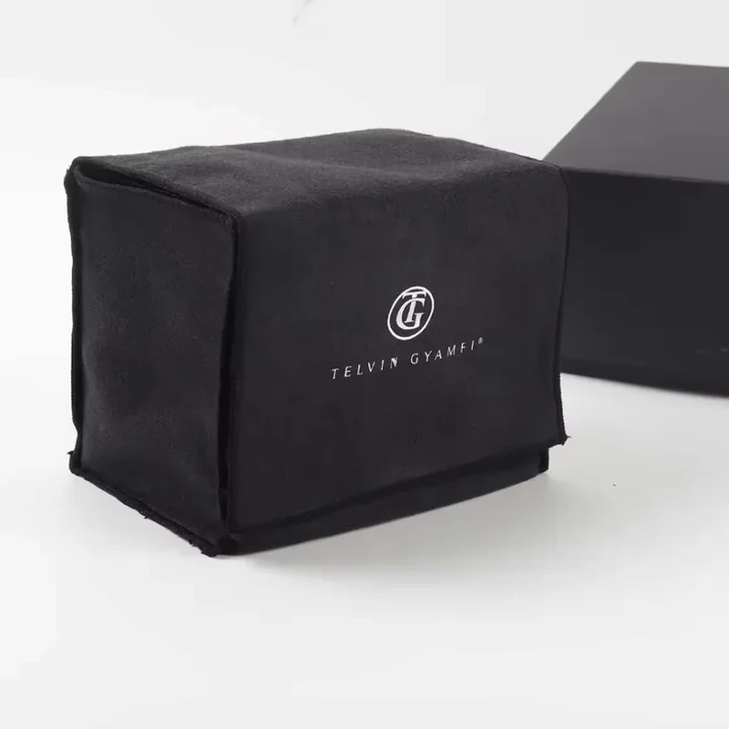 Black cube-shaped fabric dust cover with a centered printed emblem