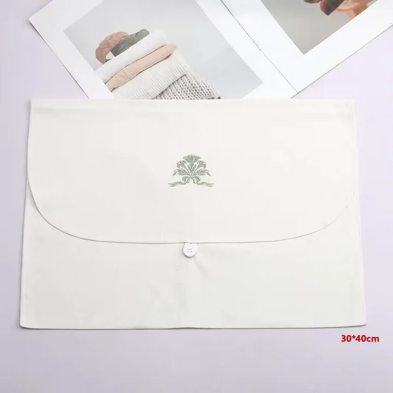 A pale envelope has a broad curved flap and a small centered fastening beneath it
