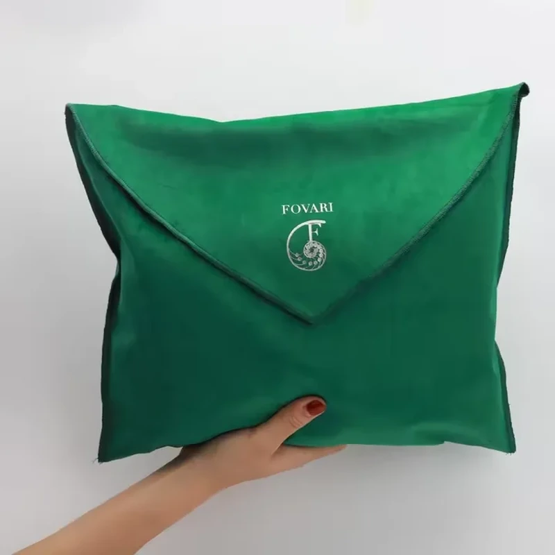A broad square body carries a deep pointed flap with a softly padded appearance