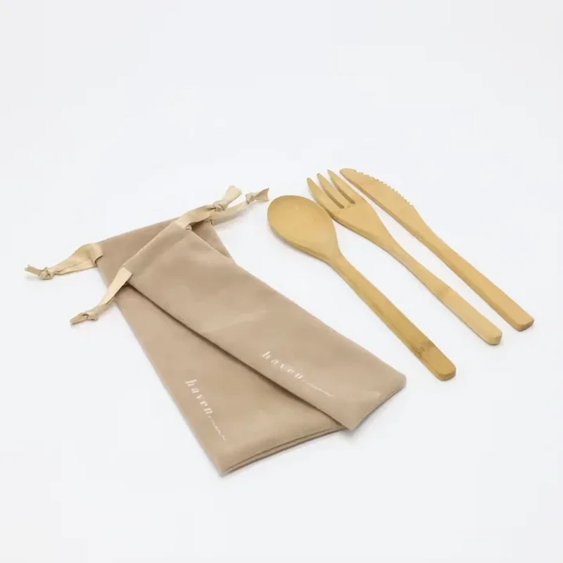 A long narrow pouch with ribbon drawstrings is shown beside a cutlery set
