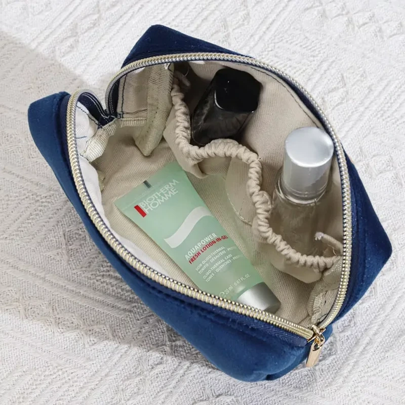 Open navy cosmetic case with elastic-top interior pockets and a central compartment.