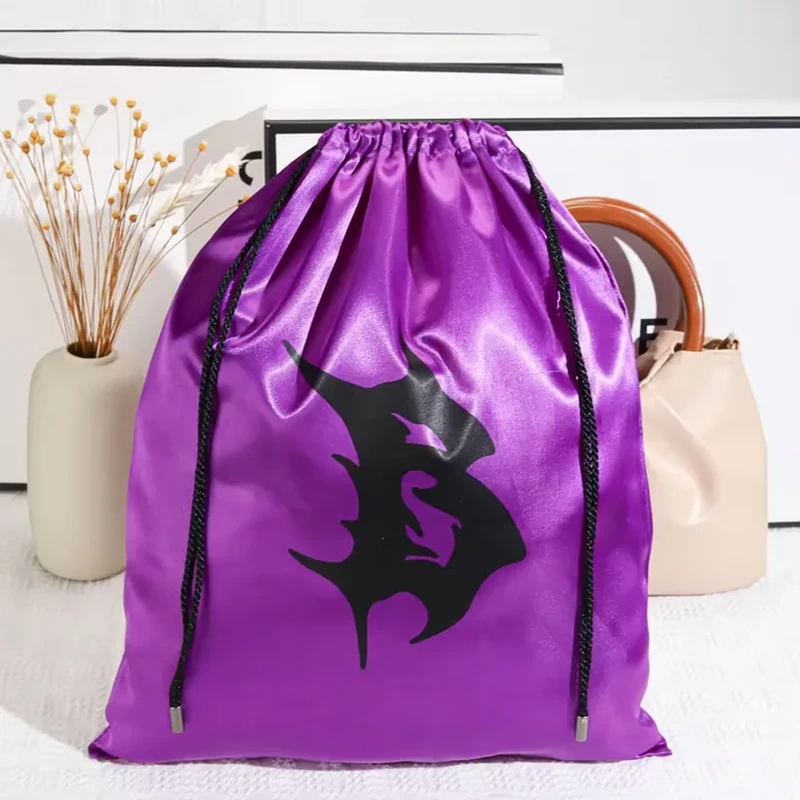 A bold dark emblem fills a tall satin bag with contrasting capped drawstrings
