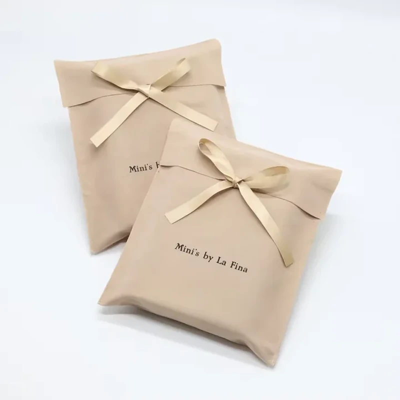 A ribbon threads through the front of a short folded-flap envelope