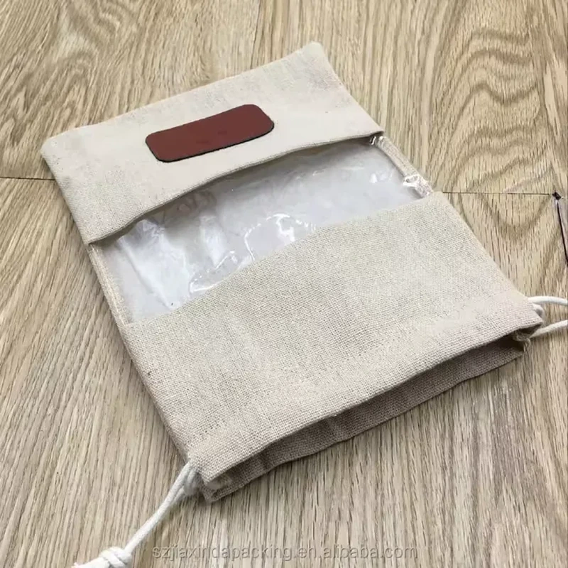 Flat woven pouch with flap, brown label patch and clear horizontal window