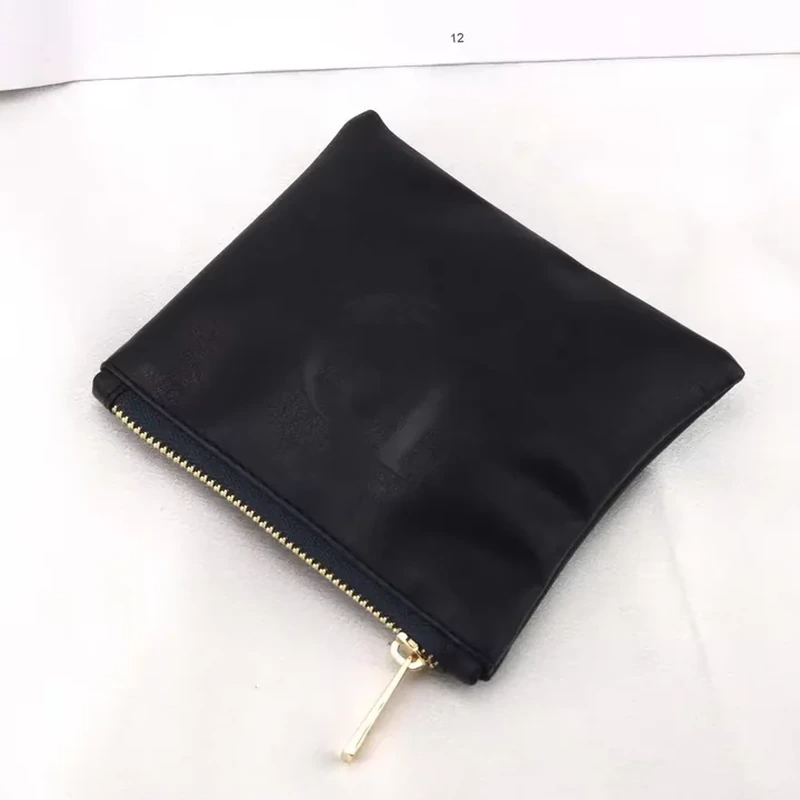 Flat black leather-look zipper pouch with a gold-colored zipper and pull