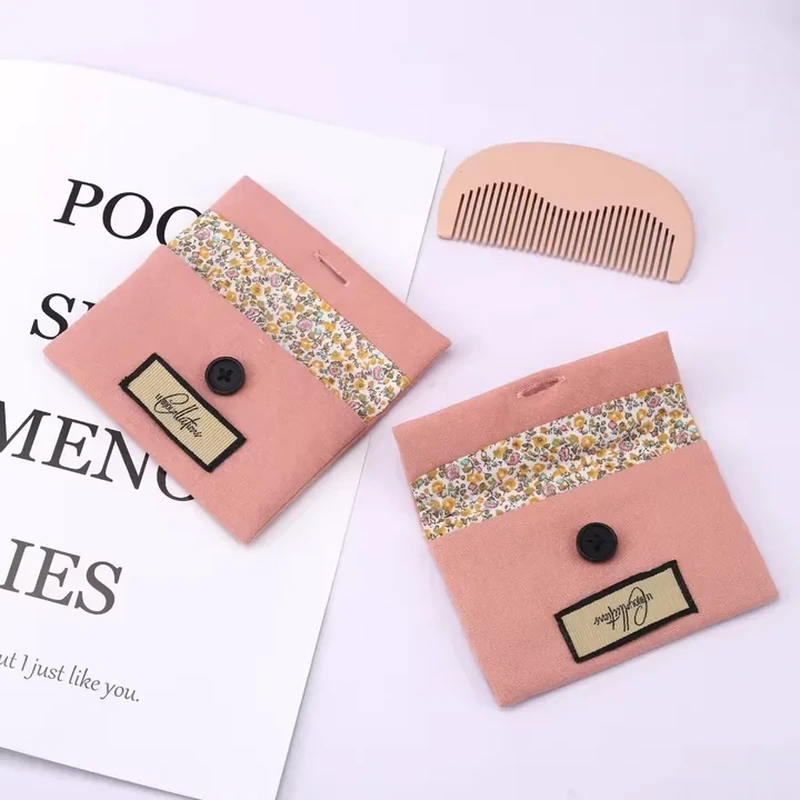 Pink button pouches with a floral fabric band and rectangular front labels.