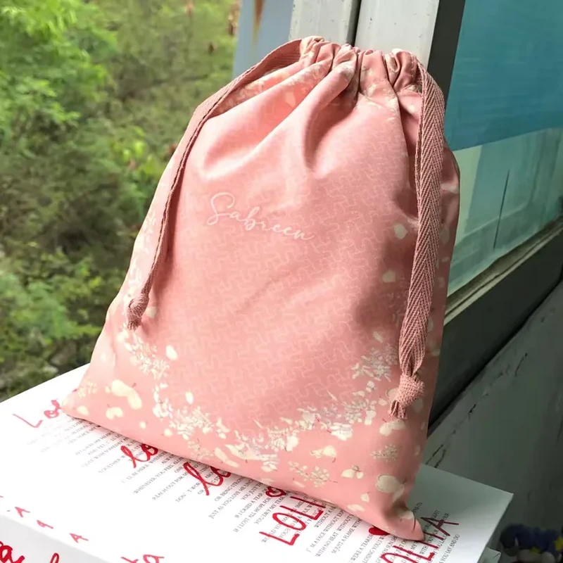 A pale pink sack has small scattered floral details around its lower body and edges
