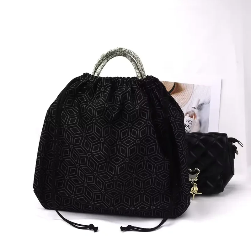 A dark patterned bag combines a geometric body design with a contrasting arched carrying handle