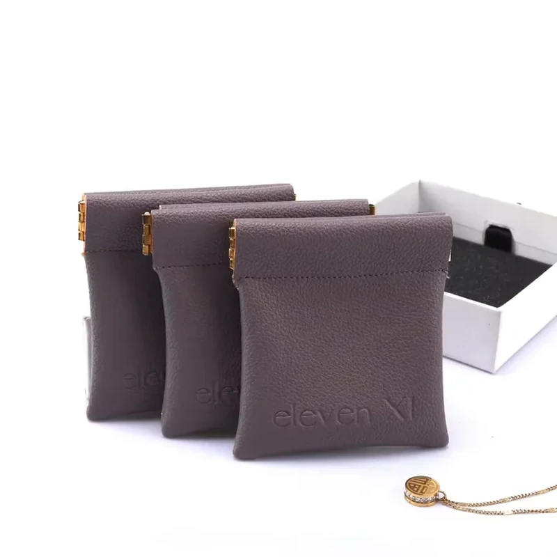 Textured dark jewelry pouches with straight rolled tops and gold-colored end details