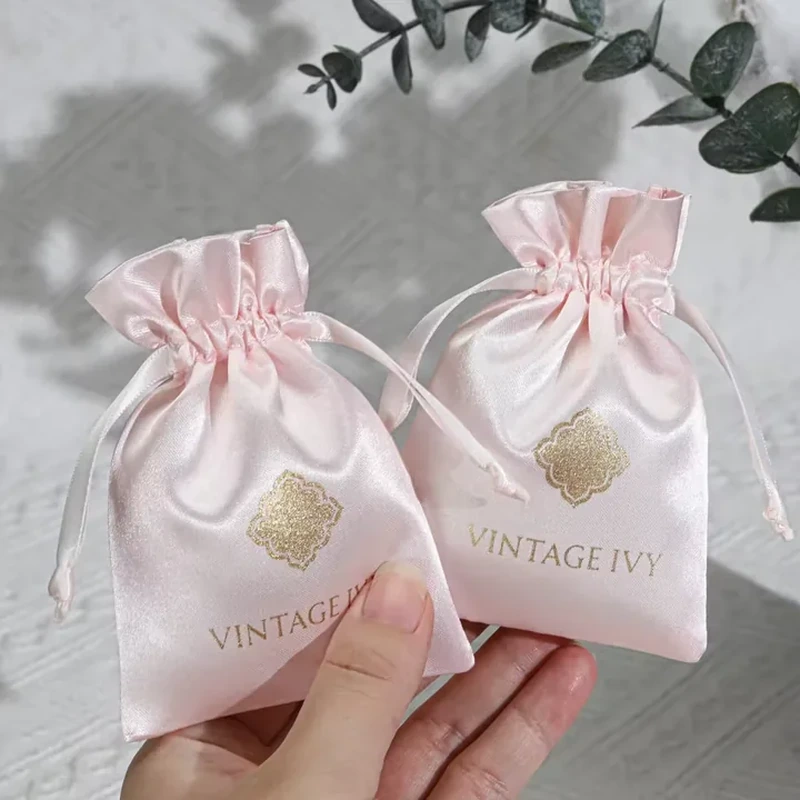 A high flared ruffle and delicate cords frame a compact satin jewelry pouch