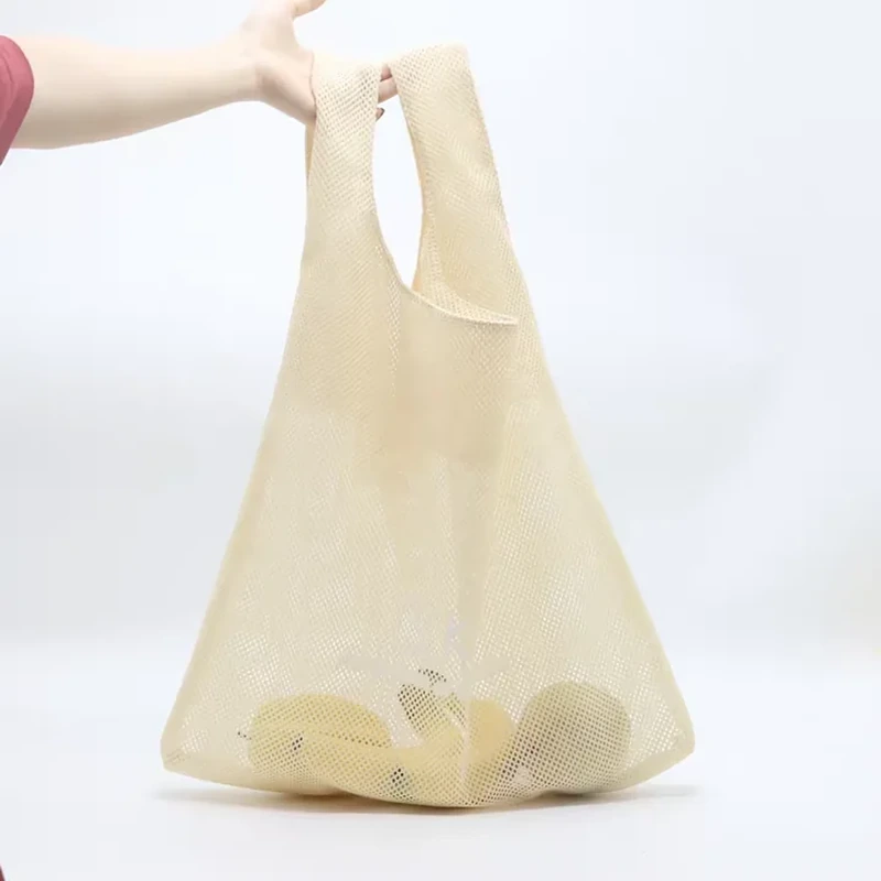 Pale fine-mesh carry bag with integrated handles and rounded contents inside