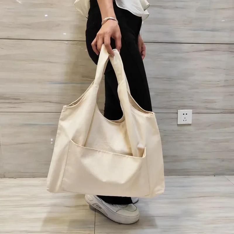 Natural tone tote with broad integrated handles and a large external patch pocket