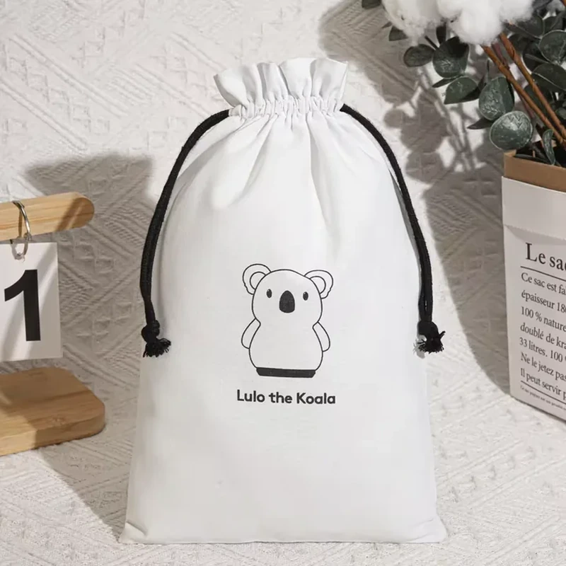 A pale pouch uses dark cords and a simple koala face illustration centered on the front