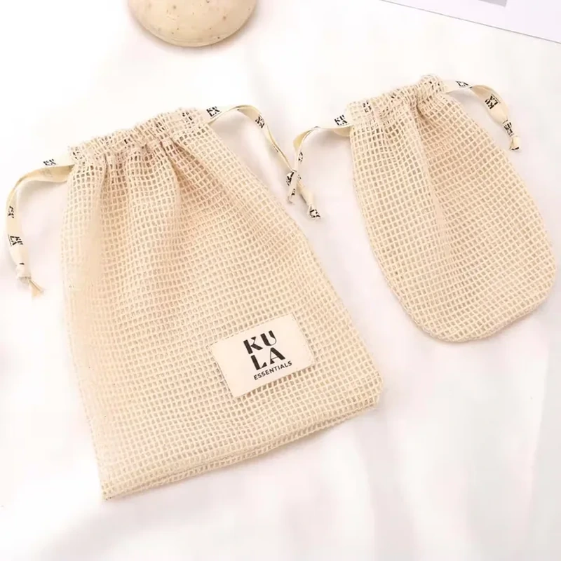 Cream mesh drawstring pouches with rectangular front labels and printed ribbon ties