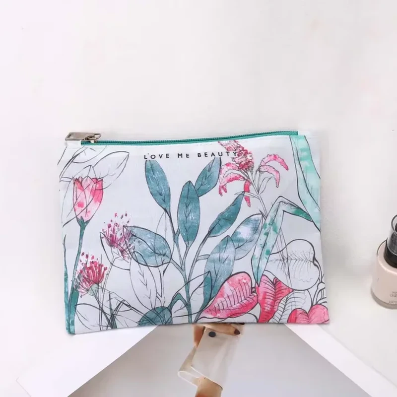 A flat rectangular zip pouch displays oversized leaves and colorful botanical illustrations