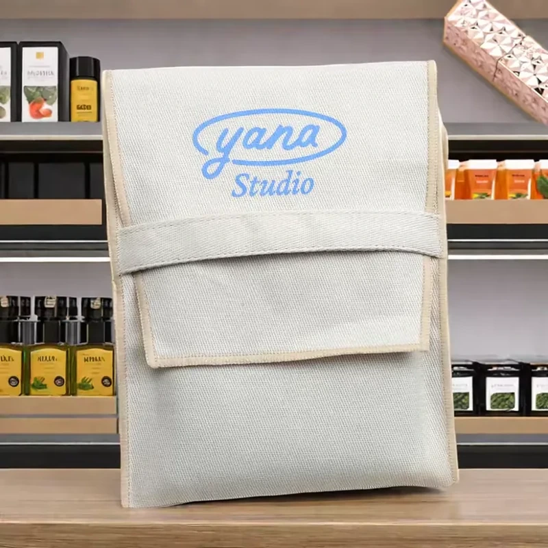 A tall pale sleeve has a wide upper flap with a layered horizontal edge and centered label