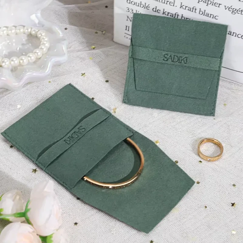 A foldable jewelry panel uses layered horizontal pockets to hold a bangle and small accessories