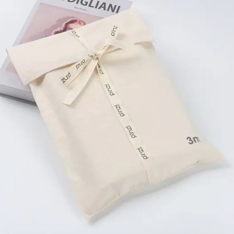 A tall flat sleeve has a folded upper flap and a long printed ribbon wrap