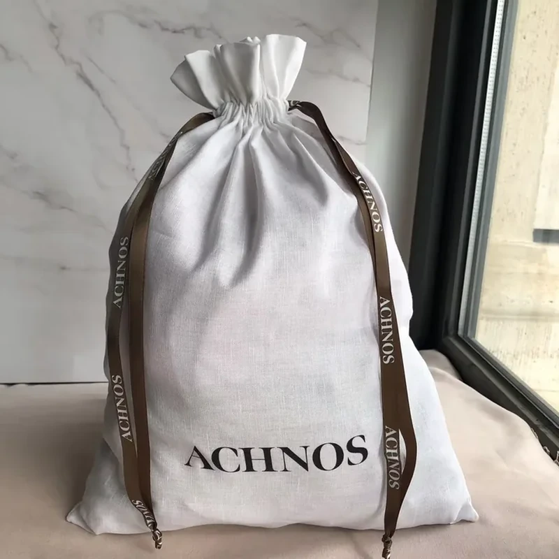 Tall pale woven drawstring bag with long brown printed ribbons