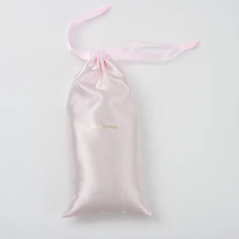 A slim satin sleeve ends in pointed lower corners and a long ribbon-tied neck