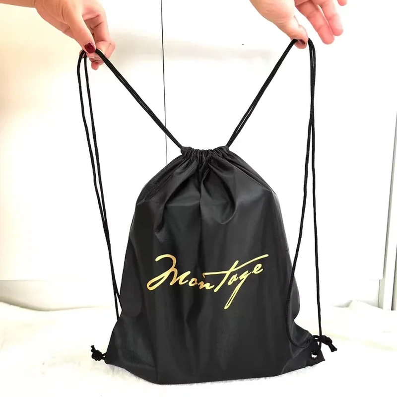 Black drawstring backpack with simple cord straps and a small gold-colored front print