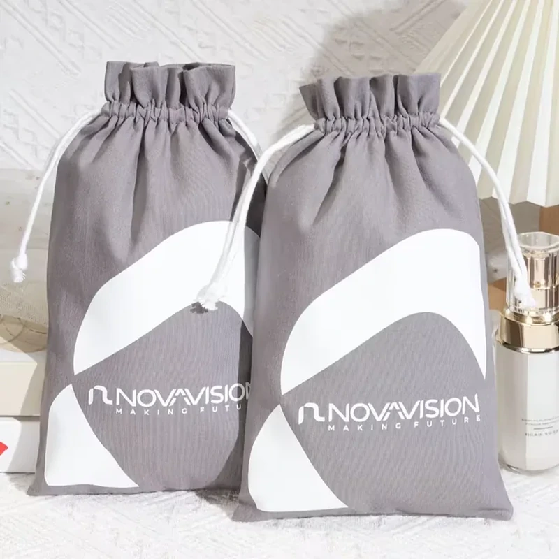 A gray drawstring pouch carries broad pale arc graphics across its lower half