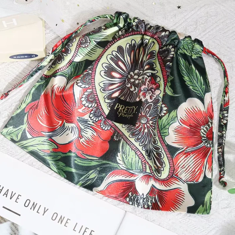 A large paisley motif and vivid botanical print wrap around a broad drawstring bag