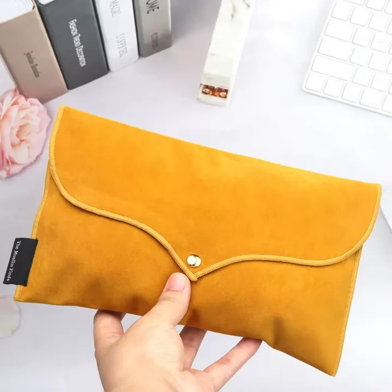 A wave-shaped flap with contrasting piping meets a central snap on this wide envelope