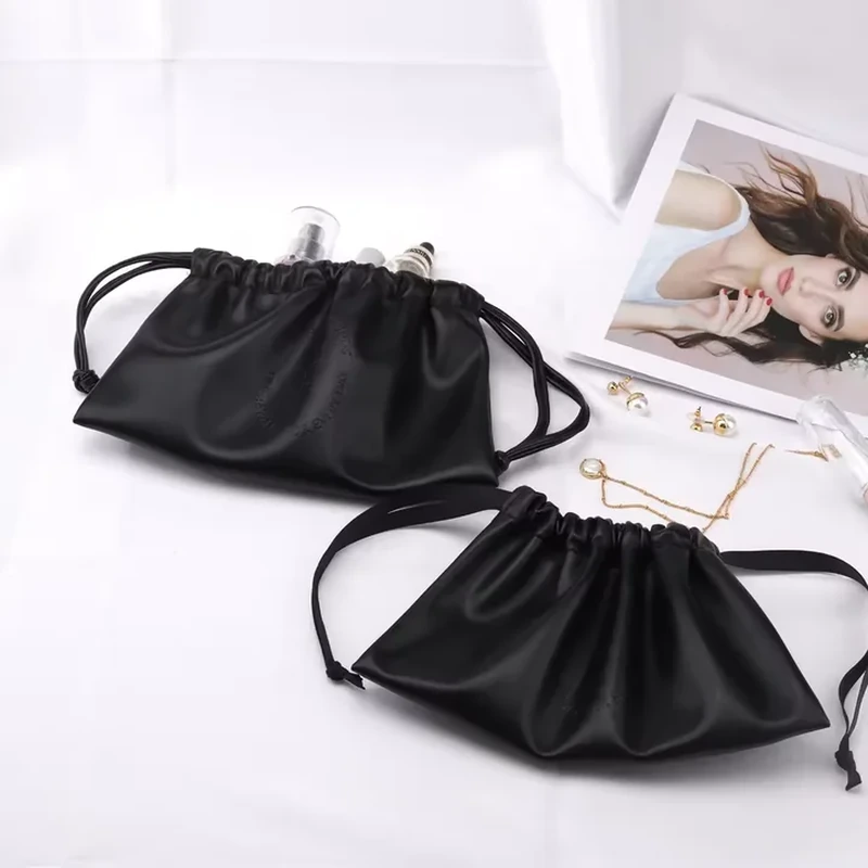 Soft black leather-look cosmetic pouches with pleated bodies and ribbon ties