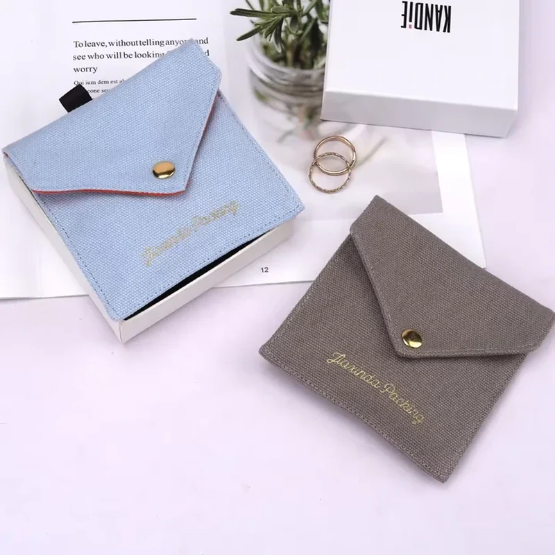 A small envelope pouch has a pointed triangular flap and a central round fastening