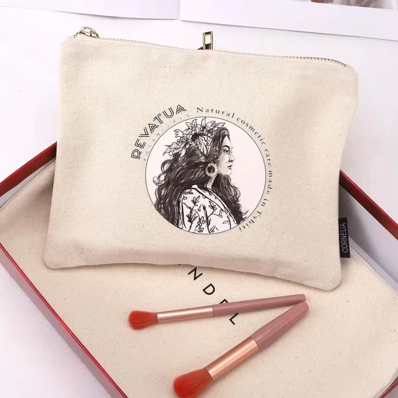 A square pale zip pouch has a portrait style front print and a small upper loop