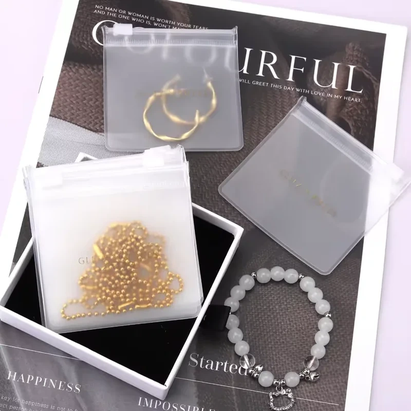 Frosted translucent jewelry sleeves with straight press-seal openings showing bracelets and earrings
