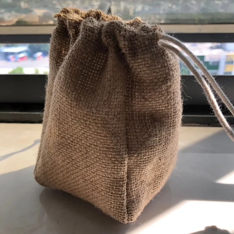 Coarse brown woven drawstring bag showing a rectangular base and full-height side seams